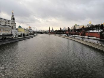 River amidst buildings in city against sky