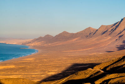 Scenic view of sea and mountains against sky