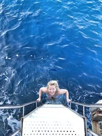 Portrait of smiling woman on ladder at sea