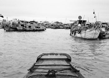 Boats moored at harbor against clear sky