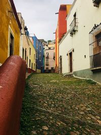 Empty alley amidst buildings in city