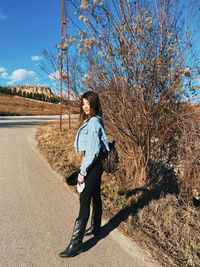 Full length of woman standing on street during sunny day