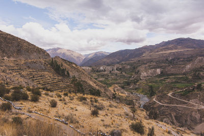 Scenic view of mountains against cloudy sky