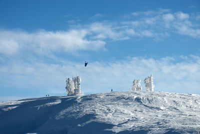 Telecommunication towers on snowly mountain  against sky