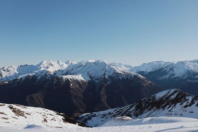 Scenic view of snowcapped mountains against clear blue sky