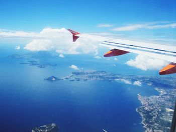 Airplane flying over sea against blue sky