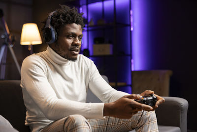 Young man using mobile phone while sitting at home