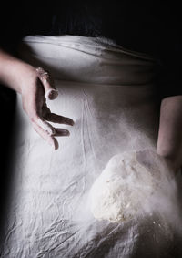 Midsection of person kneading dough