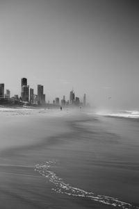 Sea and buildings against clear sky