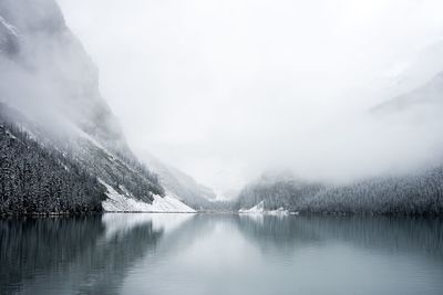 Scenic view of lake by mountains against sky