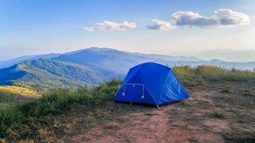 Tent on field by mountain against sky