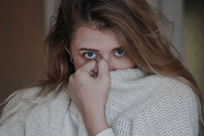 Portrait of beautiful woman wearing sweater at home