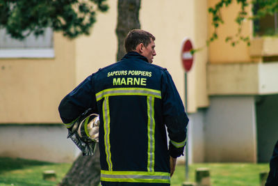 Rear view of man standing against wall