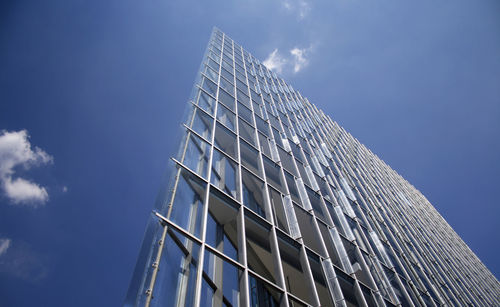 Low angle view of modern building against blue sky