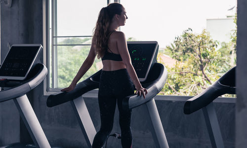 Young woman exercising on treadmill in gym