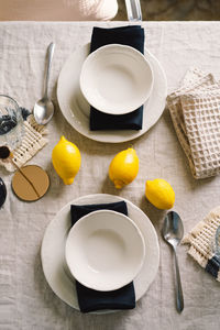 Vintage table setting with linen napkins and yellow lemons.