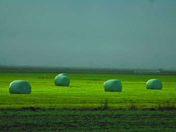 Hay bales on field against sky