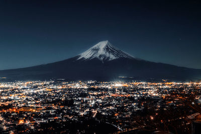 Aerial view of illuminated city against sky at night
