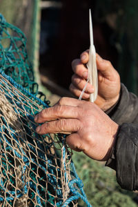 Cropped hands of person knitting wool