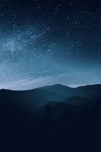 Scenic view of silhouette mountains against sky at night