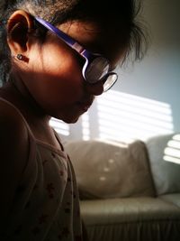 Side view of girl wearing eyeglasses at home