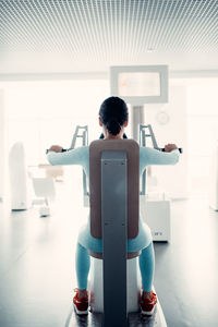 Rear view of woman sitting on chair