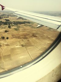 Cropped image of airplane wing over landscape