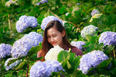 Portrait of young woman on purple flowering plants