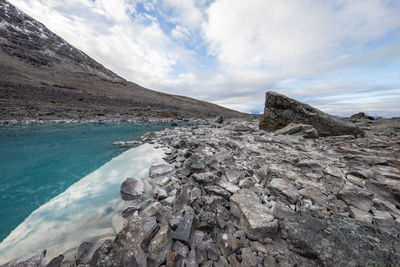 Rock formations by sea against sky