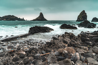 Rocks on beach against sky