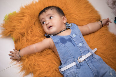 Portrait of cute baby lying on bed at home