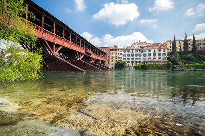 Arch bridge over river against sky