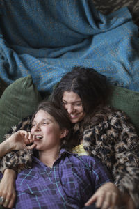 Portrait of a smiling young woman lying on bed