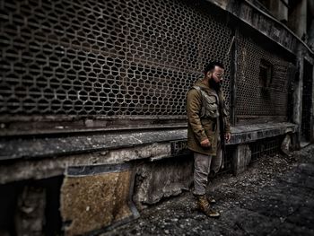 Man standing on wall in city