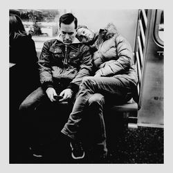 Men sitting on seat in train