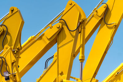 Low angle view of yellow flags against clear blue sky