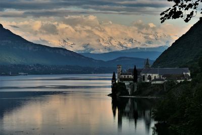 Scenic view of lake and mountains against sky during sunset