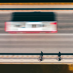 Blurred motion of people riding motorcycle on road