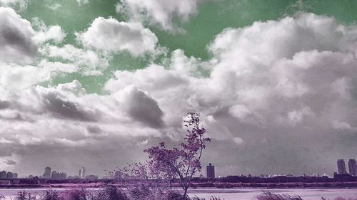 View of cityscape against cloudy sky