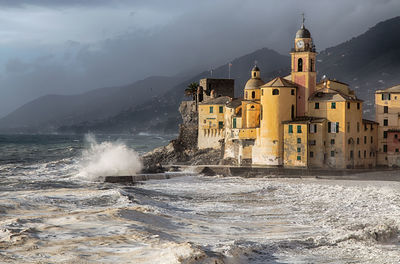 View of buildings by sea against sky