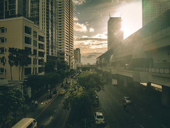 Traffic on city street by buildings against sky