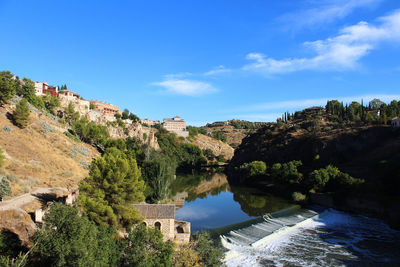 Scenic view of river and mountains against blue sky