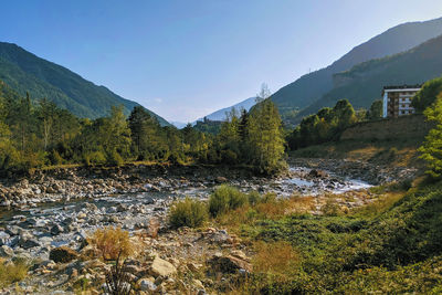 Scenic view of riverbed and mountains against sky