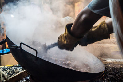 Close-up of man preparing food in snow