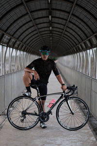 Man riding bicycle on bridge