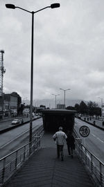 Rear view of people walking on street in city