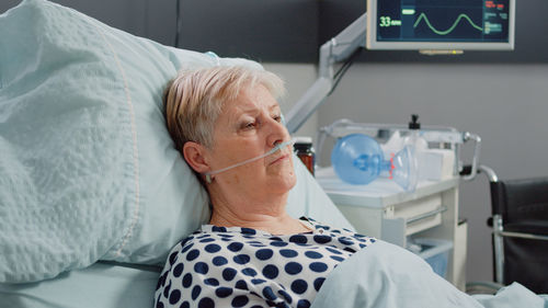 Female patient resting on bed in hospital