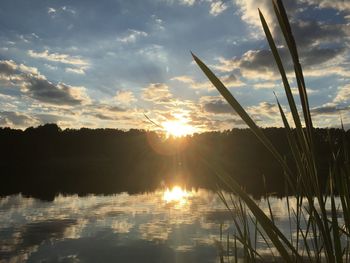 Sun shining over lake during sunset