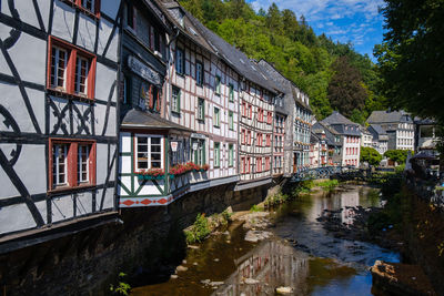 Bridge over river by buildings in city