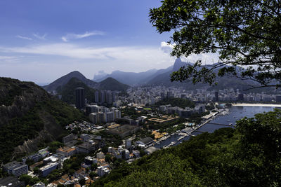 High angle view of city by sea against sky